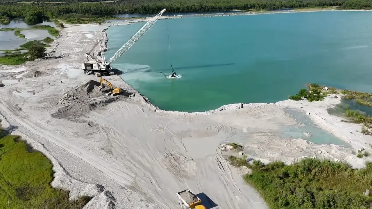 Wide view of a graded lake site with managed drainage in Bonita Springs, FL